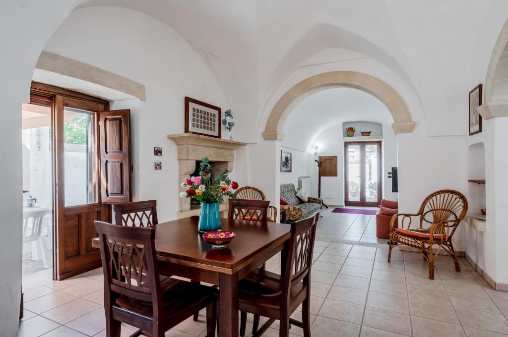 eine Küche und ein Esszimmer mit einem Tisch und Stühlen in der Unterkunft Casetta del Manco in Corigliano dʼOtranto