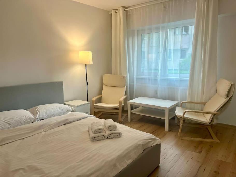 een slaapkamer met een bed en 2 stoelen en een raam bij Cipariu Corner in Cluj-Napoca