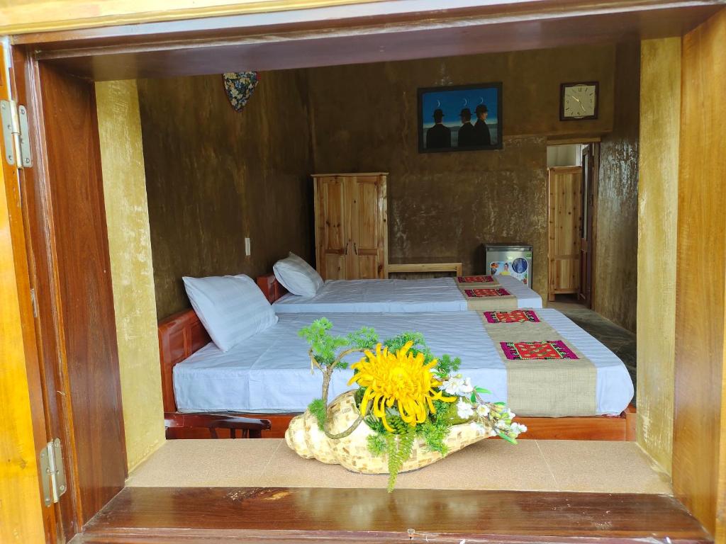 sypialnia z łóżkiem ze słonecznikiem na stole w obiekcie Dìn Homestay Nặm Đăm w mieście Hà Giang