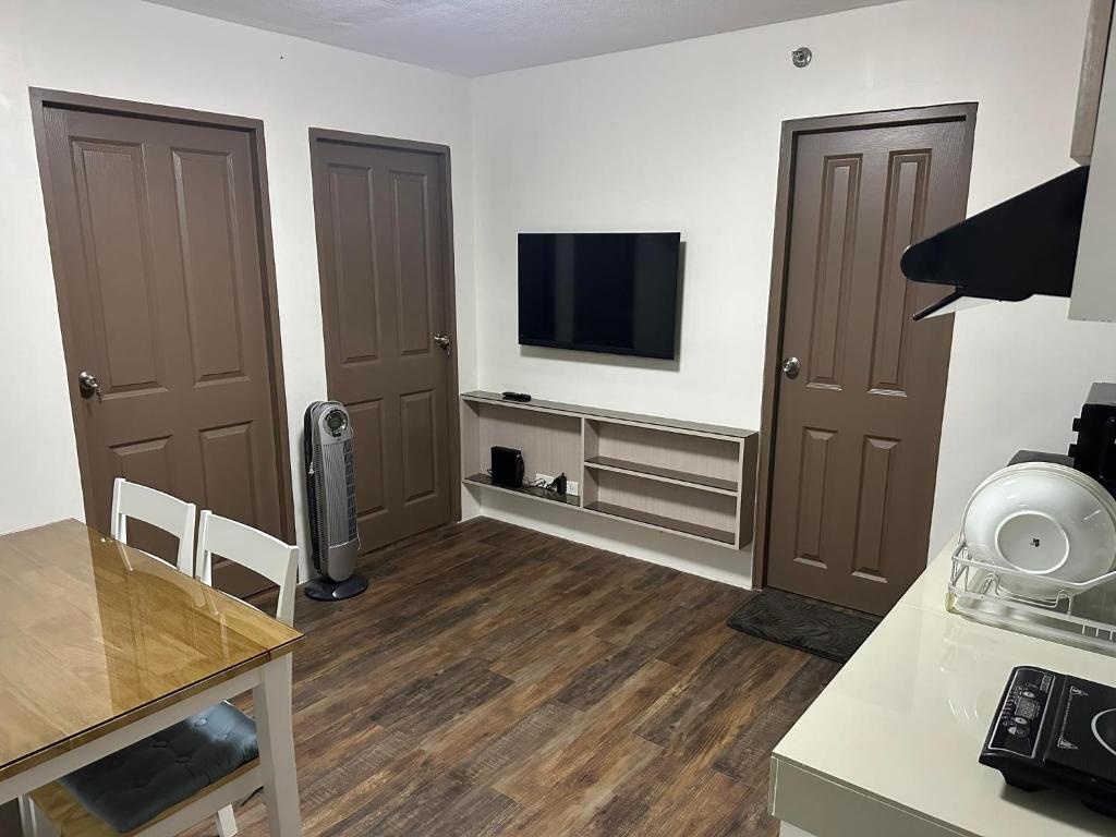 ein Wohnzimmer mit zwei braunen Türen und einem Flachbild-TV in der Unterkunft One Spatial Condominium, 2-Bedroom Unit #2920 in Iloilo City