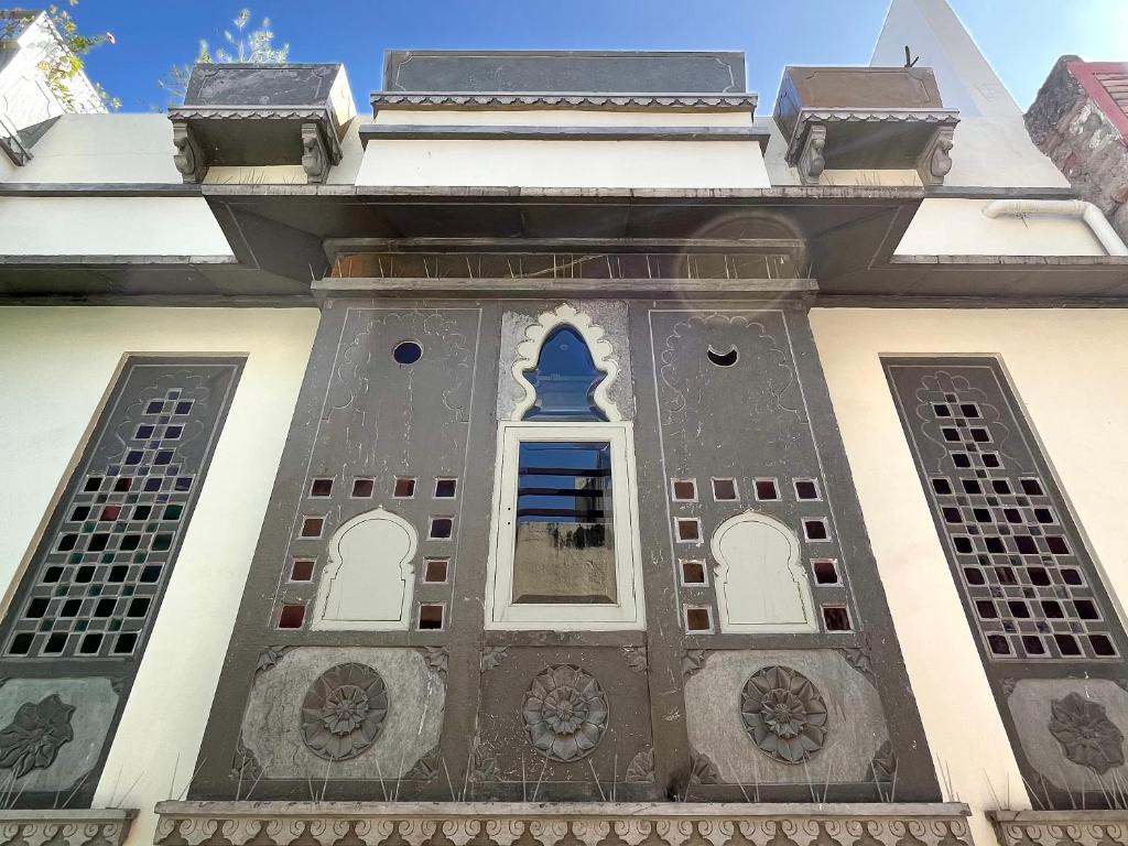 un bâtiment avec une fenêtre bleue sur son côté dans l'établissement Smiling Sparrows 1 and 2 Bedroom Villas, à Udaipur