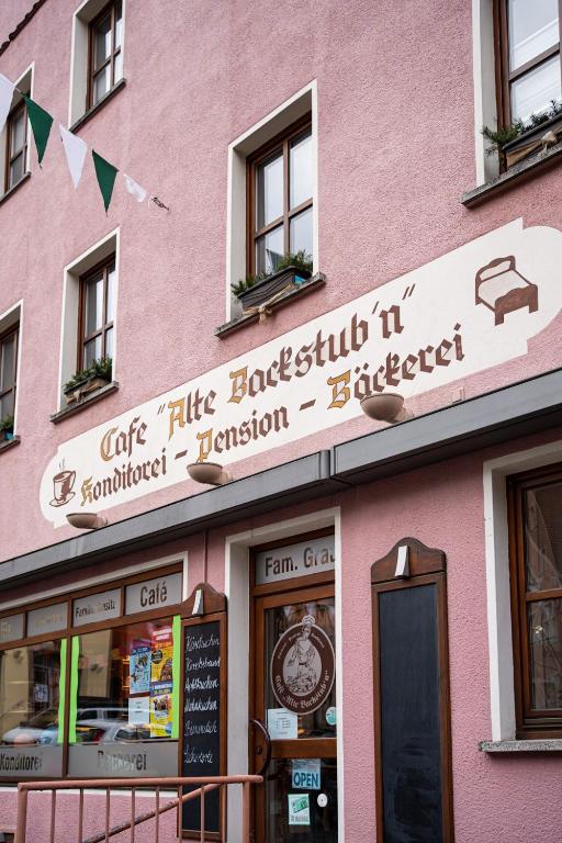 un edificio rosa con un cartel en la parte delantera en Cafe Alte Backstubn, en Spalt