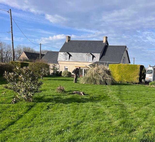 une personne marchant dans une cour devant une maison dans l'établissement Villa CHESTER 9 km d'Omaha Beach, à Trévières