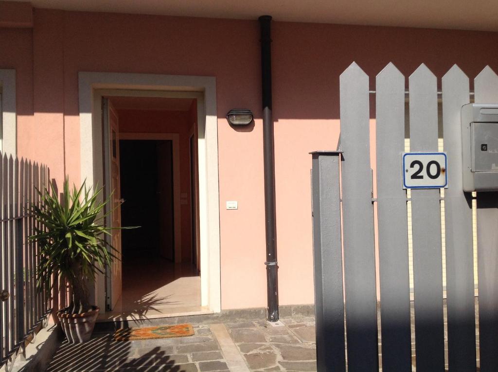 a pink house with a gate and a door at Appartamenti Jamaica in Sirmione