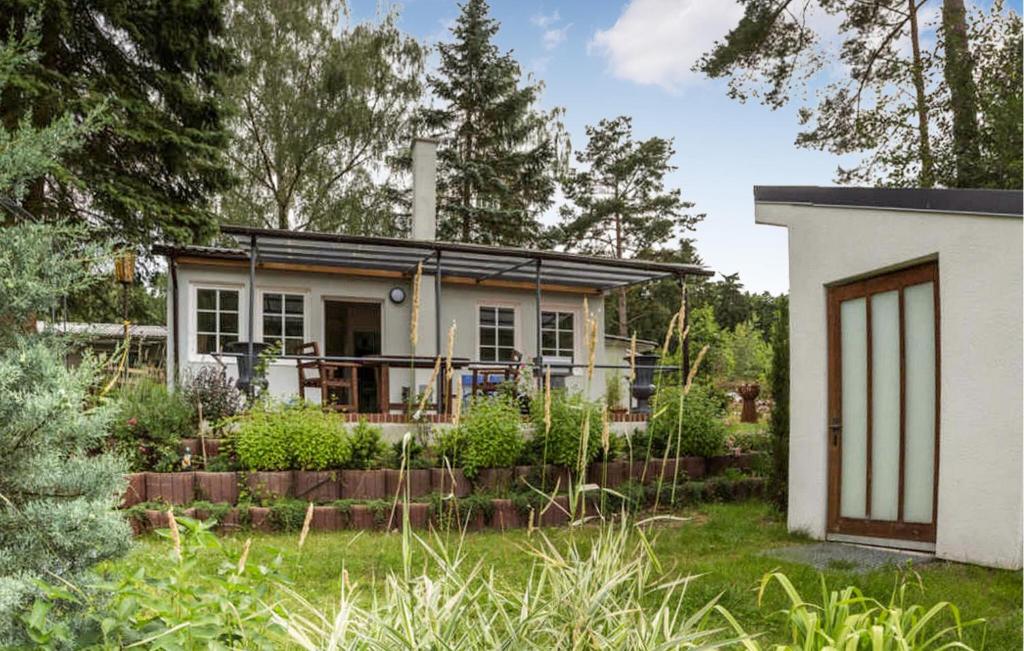 uma pequena casa com um jardim em frente em Nice Home In Rheinsberg Ot Warenthi With Sauna em Warenthin