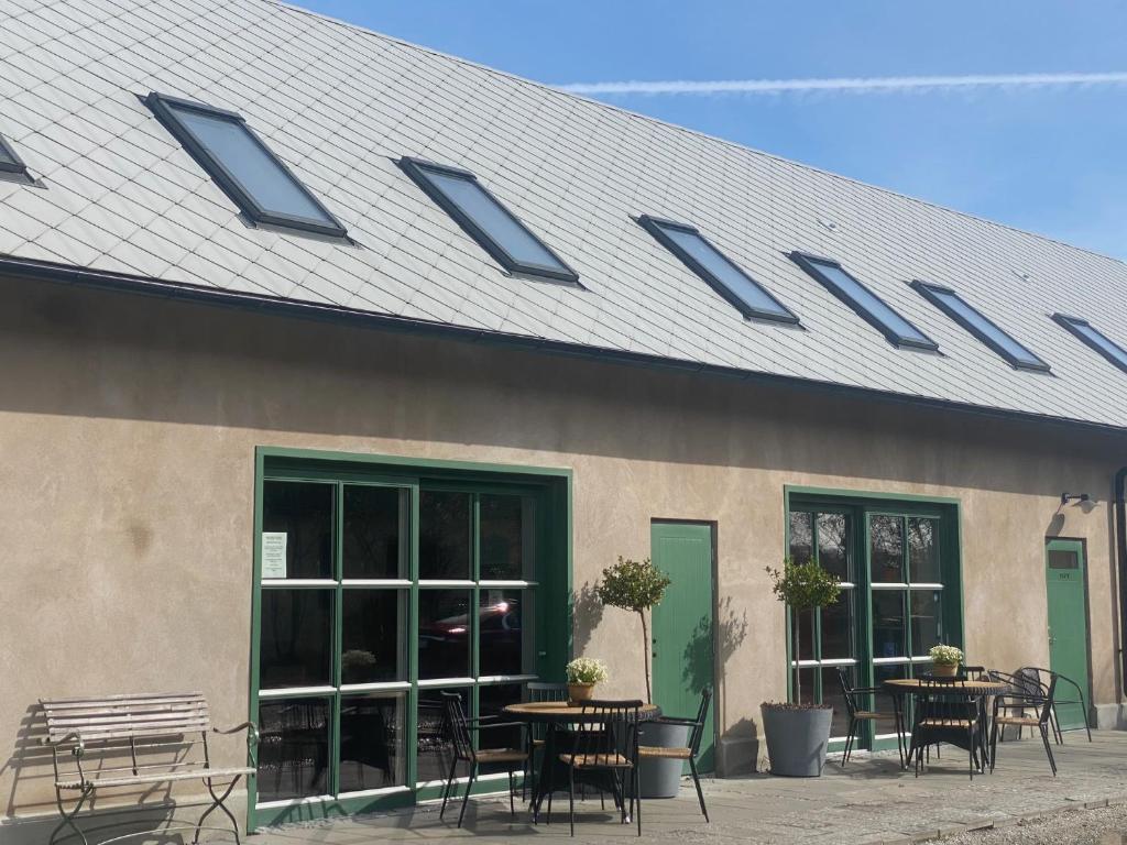 een gebouw met tafels en stoelen en een dak bij Brohuspark in Lomma