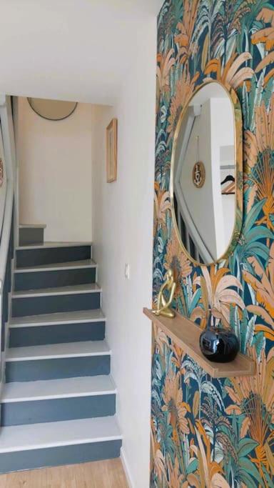 un couloir avec un escalier et un miroir mural dans l'établissement Maison de ville - wifi - checkin autonome, à Saint-Martin-sur-Oust
