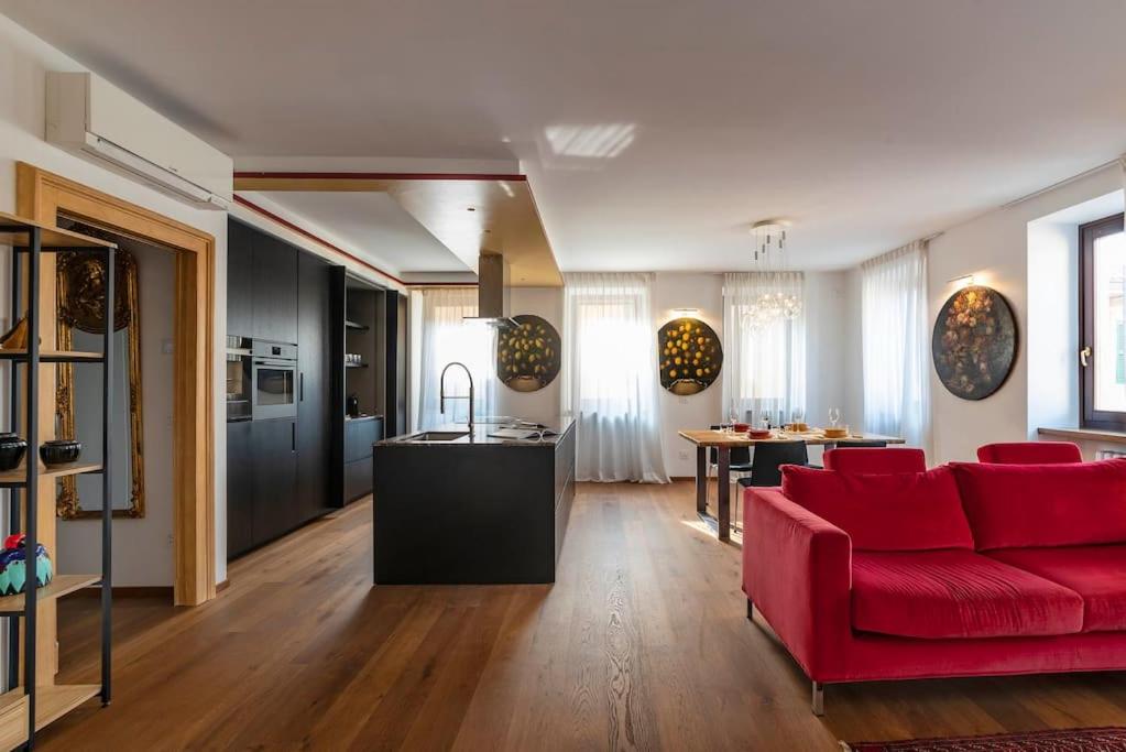 a living room with a red couch and a kitchen at Italianflat - Duomo Deluxe in Verona