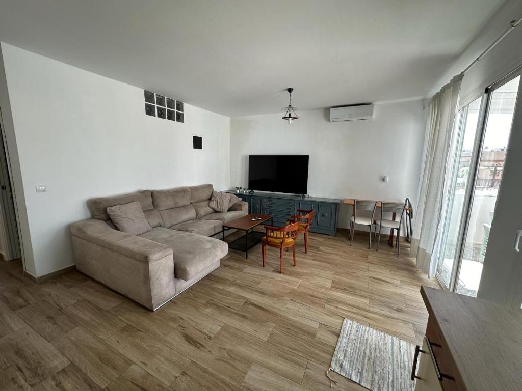 uma sala de estar com um sofá e uma mesa em ATICO AMPLIO Y LUMINOSO em Sevilha