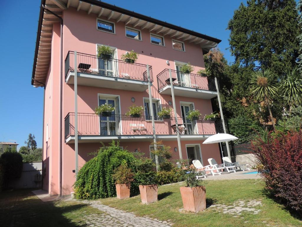 różowy budynek z roślinami na balkonach w obiekcie Villa Rosa w mieście Moniga