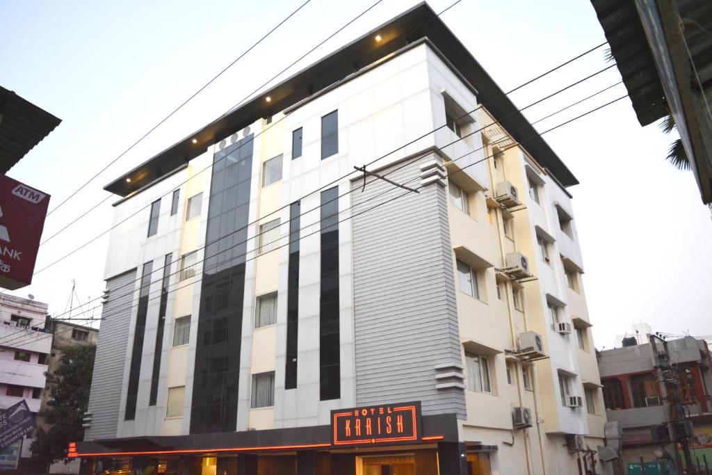 a tall white building with a sign in front of it at HOTEL KRRISH in Patna