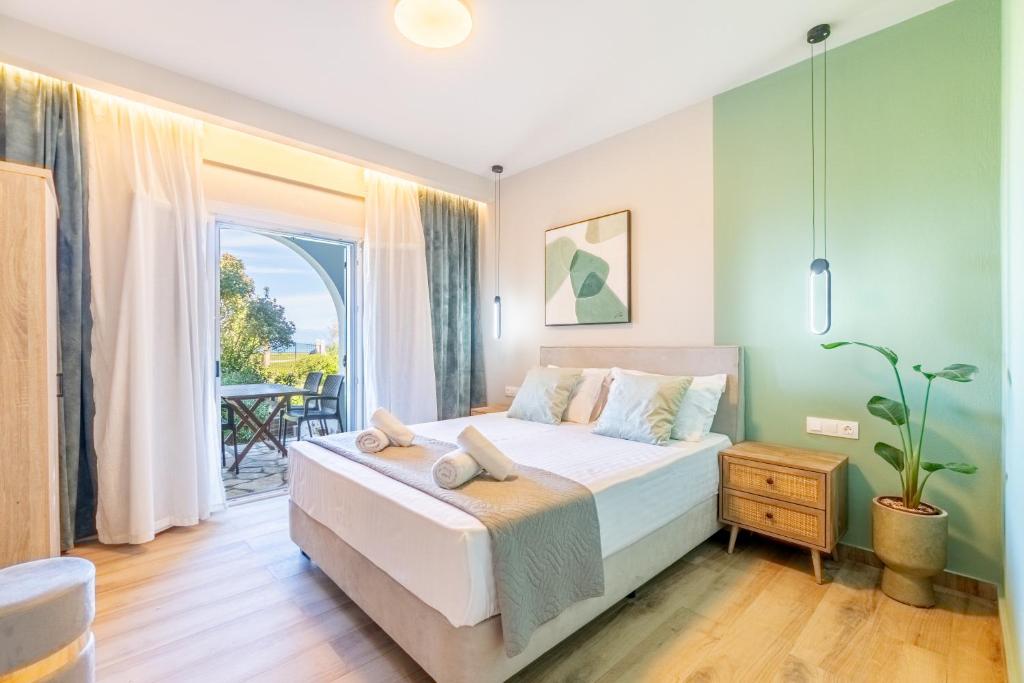 a bedroom with a large bed and a balcony at Villa Maria in Almiros Beach