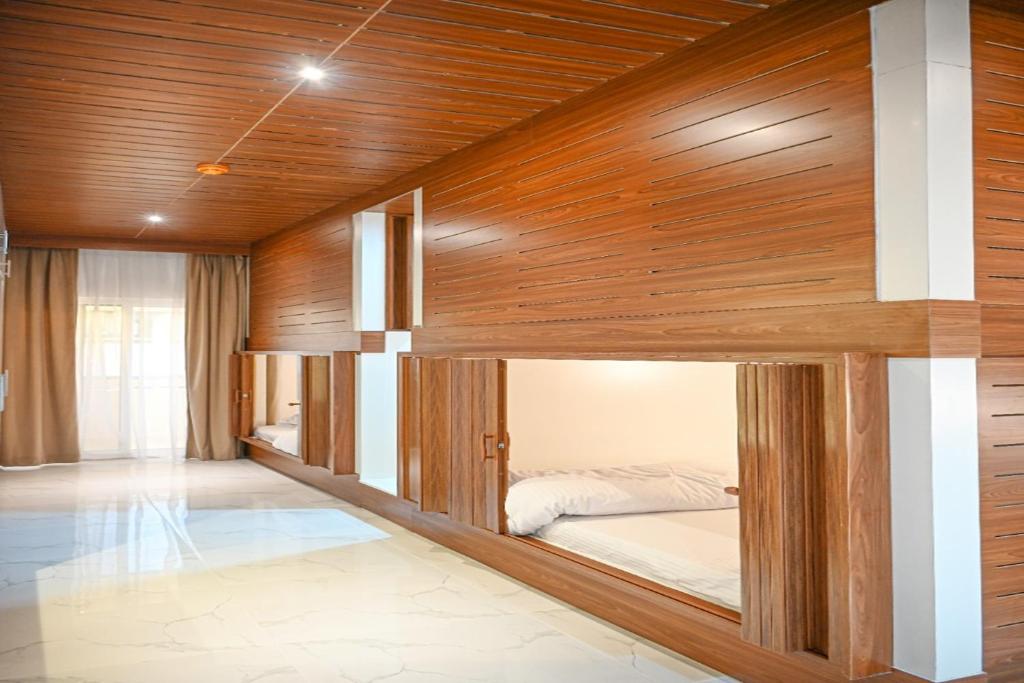 Cama en habitación con paredes de madera en Yoi Pod Hostel - Deira Al Rigga en Dubái