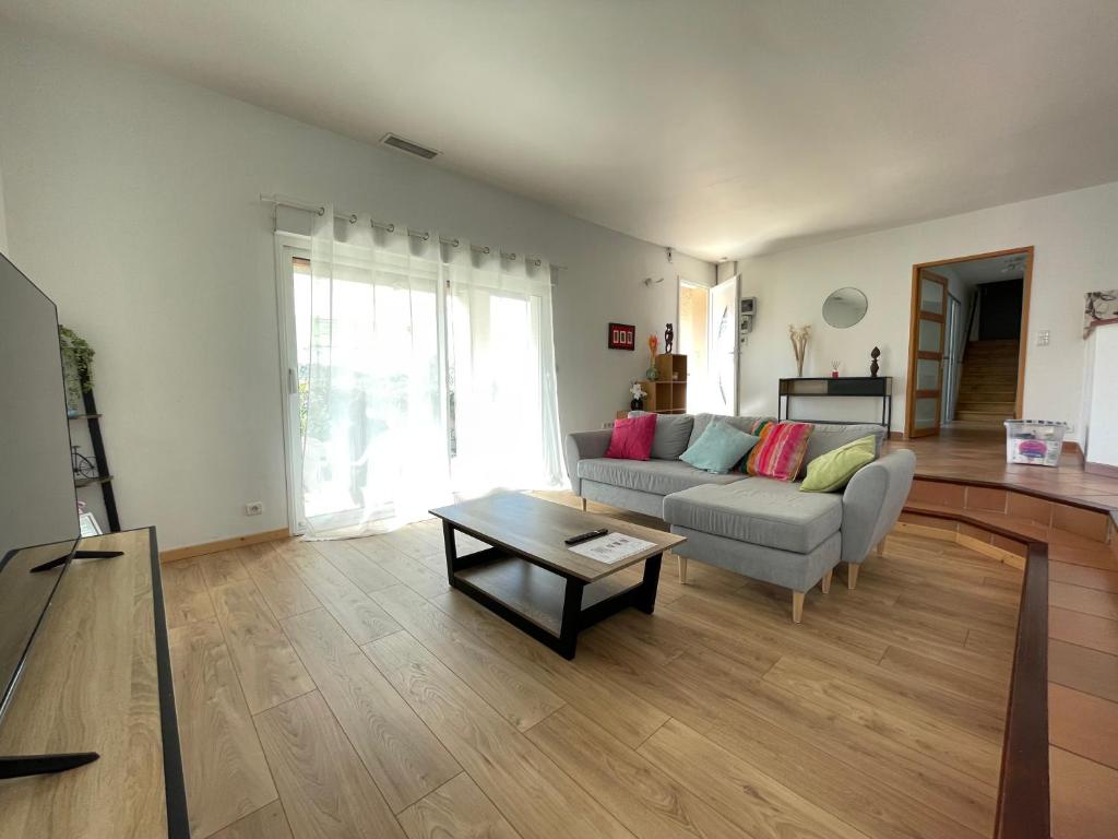 een woonkamer met een bank en een tafel bij Charmante maison de 3 chambres - Proche de Montpellier in Prades-le-Lez