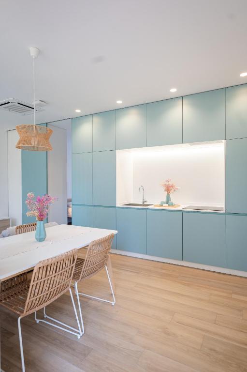 a dining room with a white table and chairs at Apartamentos Benicasim - La Casa Encendida in Benicàssim