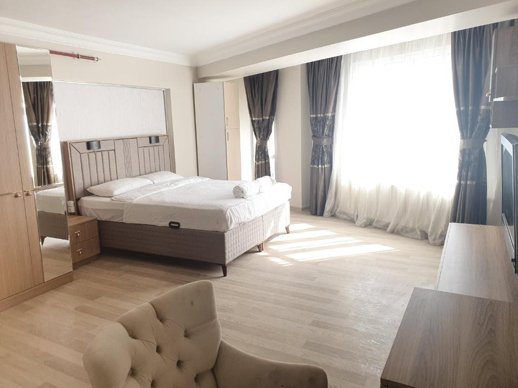ein Schlafzimmer mit einem Bett, einem Stuhl und einem Spiegel in der Unterkunft KADIKÖY BRISTOL HOTEL in Istanbul