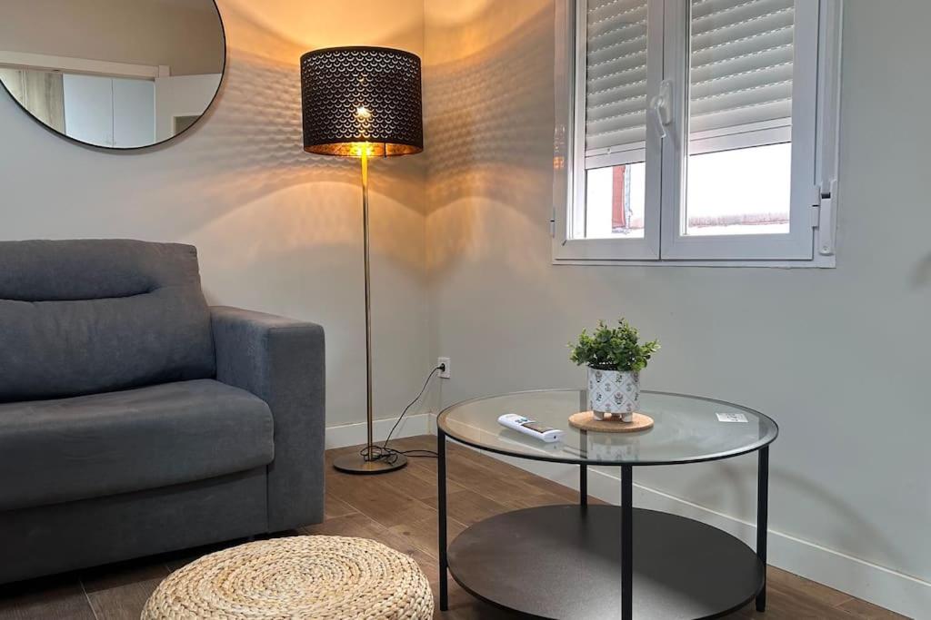 ein Wohnzimmer mit einem Sofa, einem Tisch und einer Lampe in der Unterkunft Meta Habitat Ramon Lujan A in Madrid