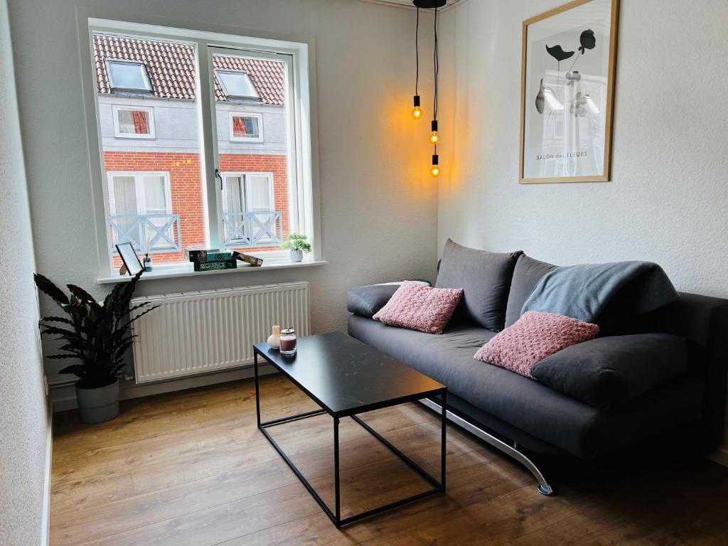 sala de estar con sofá y mesa en The Old Hotel Silkeborg - 1MTH en Silkeborg