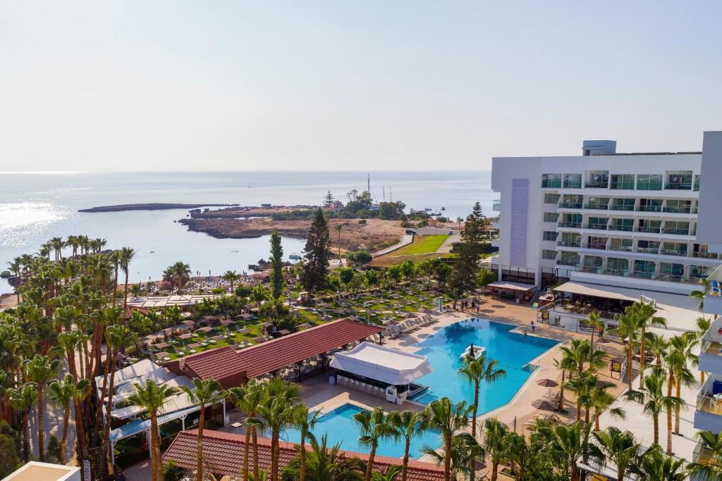 uma vista aérea de um resort com piscina e oceano em Cavo Maris Beach Hotel em Protaras