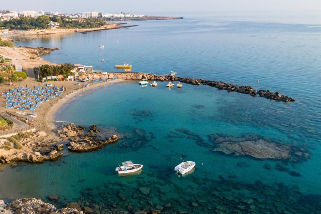 an aerial view of a beach with boats in the water at Cavo Maris Beach Hotel in Protaras