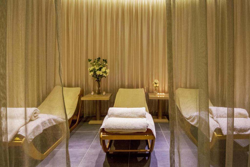 a hospital room with two beds and a vase of flowers at Cavo Maris Beach Hotel in Protaras