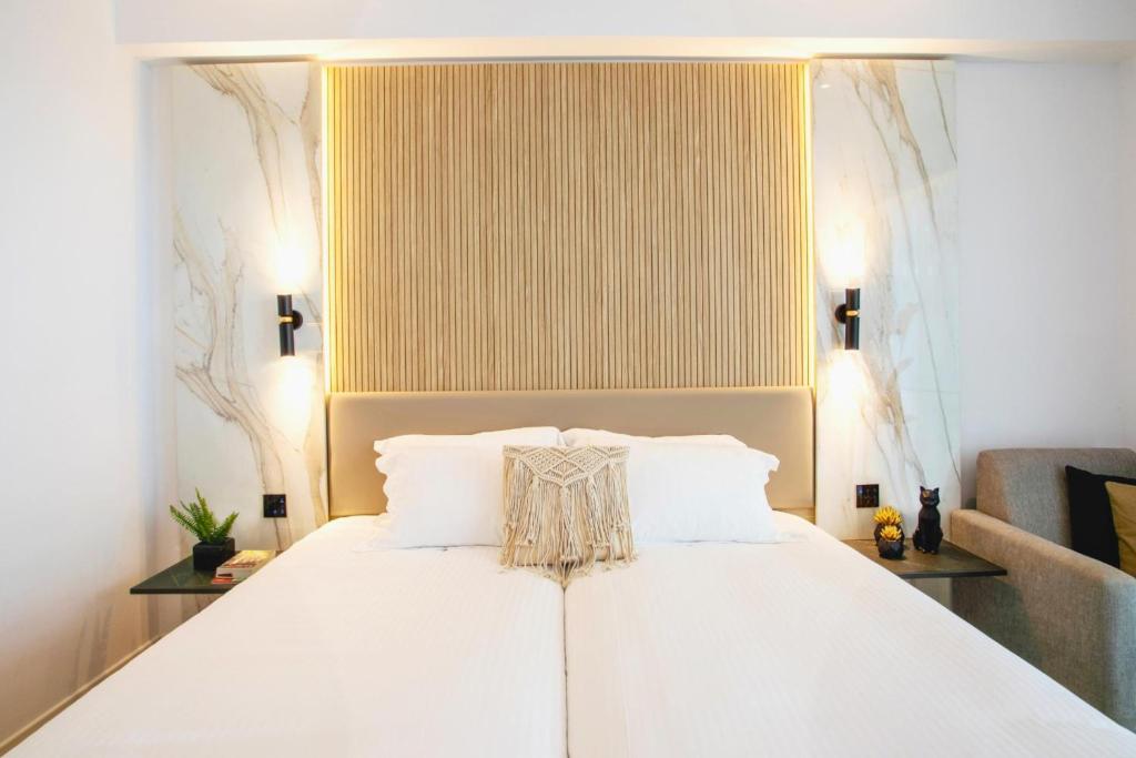 a bedroom with a white bed with white pillows at Cavo Maris Beach Hotel in Protaras