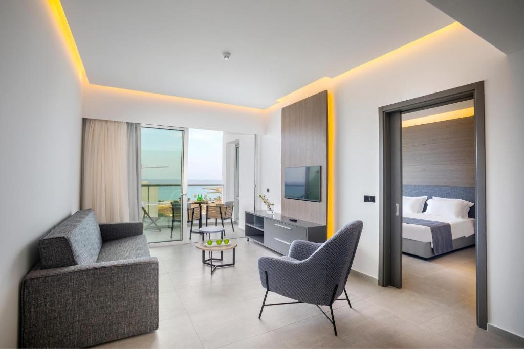 a bedroom with a bed and a living room at Cavo Maris Beach Hotel in Protaras