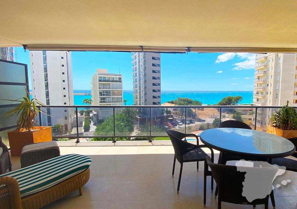 een balkon met een tafel en stoelen en uitzicht op de oceaan bij CostaBlancaDreams Morello 5A in Calpe in Calpe
