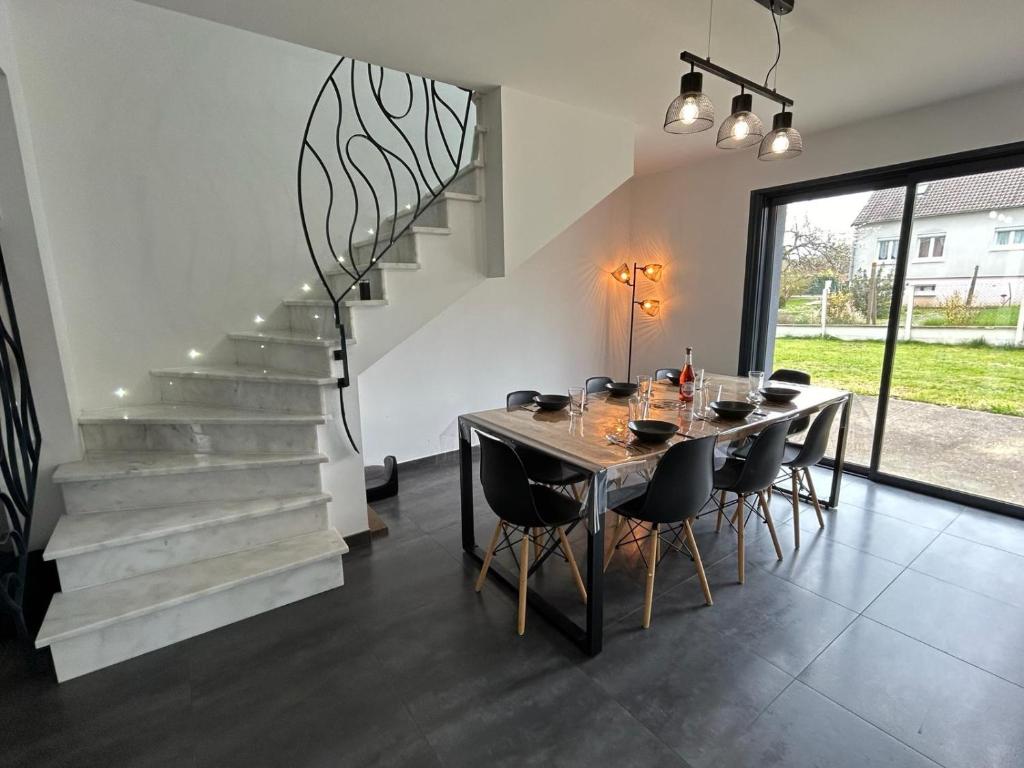 a dining room with a table and a staircase at Maison privative 6 chambres in Champhol