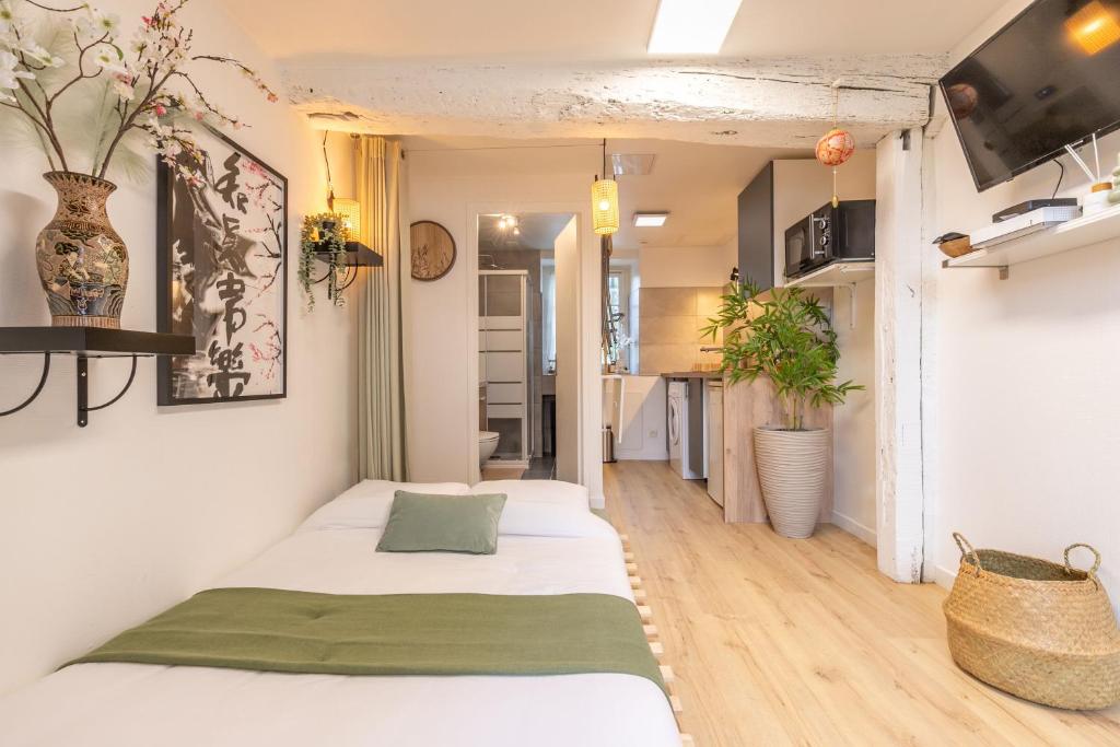 ein Schlafzimmer mit zwei Betten und eine Küche in der Unterkunft Au Soleil Levant - Havre Zen à Orléans in Orléans