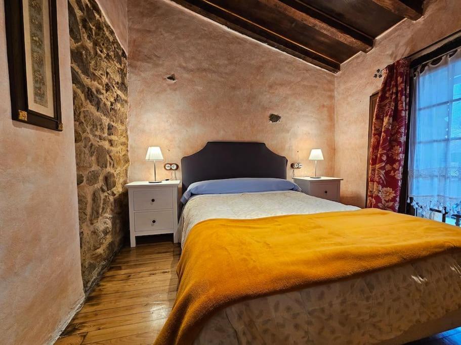 a bedroom with a bed with a yellow blanket on it at 14A09 Casa de la Capilla in Colunga