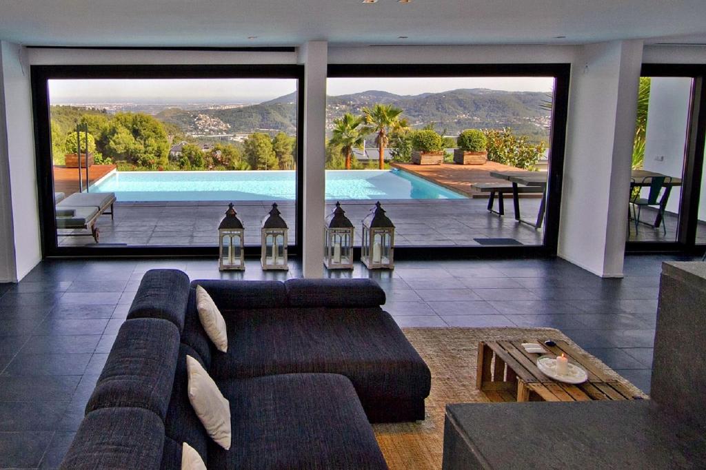 uma sala de estar com um sofá e uma piscina em Holiday Home Alexander Plana em Pallejá