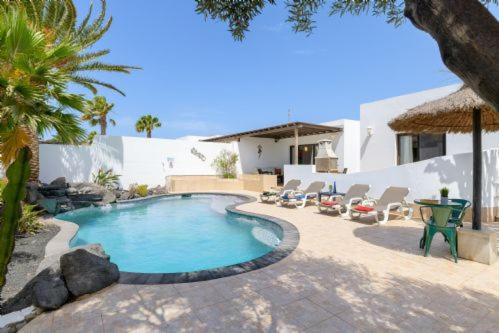 a swimming pool in front of a house at Villa Primera in Playa Blanca