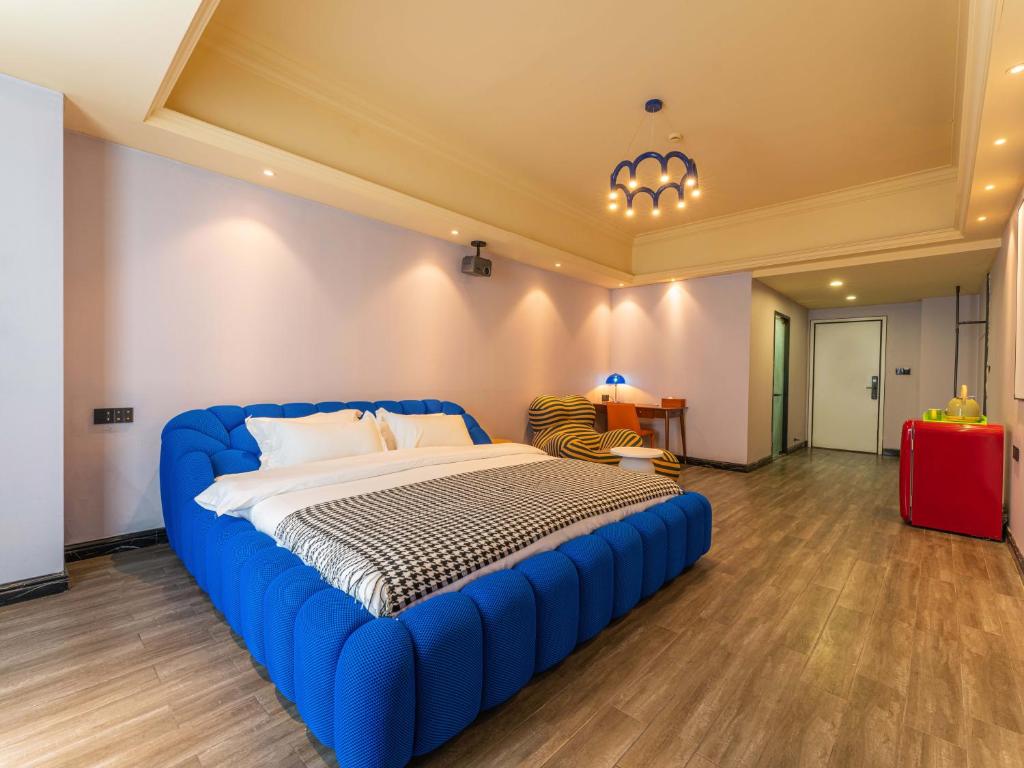 a bedroom with a large blue bed in a room at Wind sleeping Color Hotel - Free car to the Canton Fair-Line7 18Nancun Wanbo STN in Guangzhou