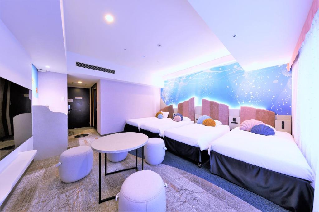 a room with four beds and a table and chairs at Hotel Keihan Universal Tower in Osaka
