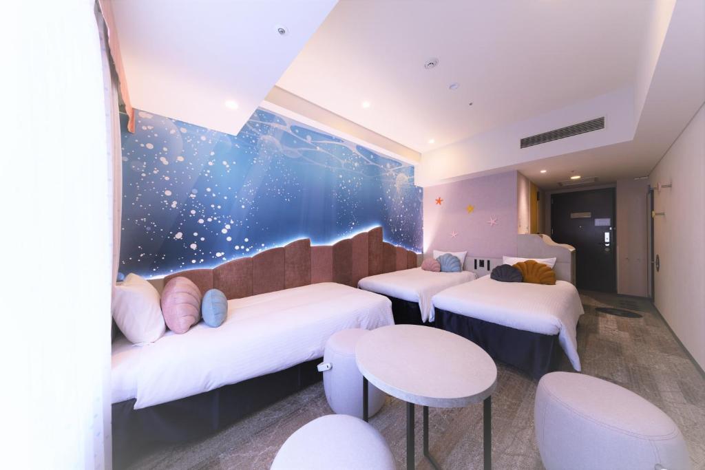 a room with two beds and a table and chairs at Hotel Keihan Universal Tower in Osaka