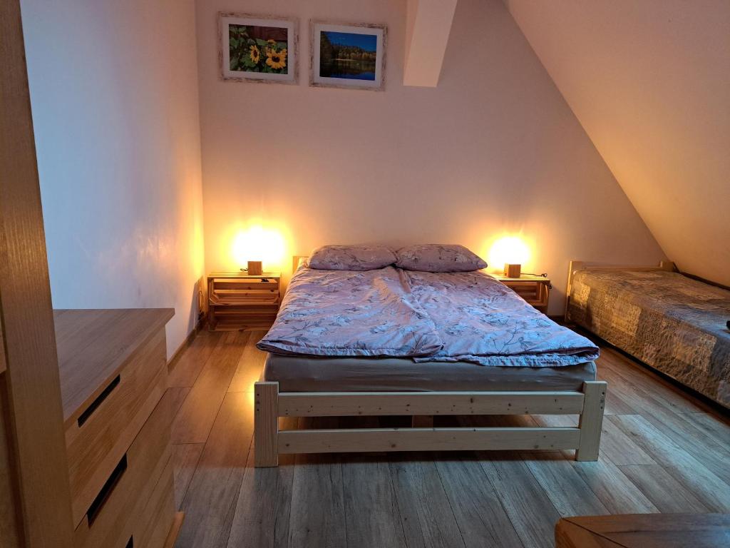 a bedroom with a bed with two lamps on both sides at Chatka Kurki in Kurki