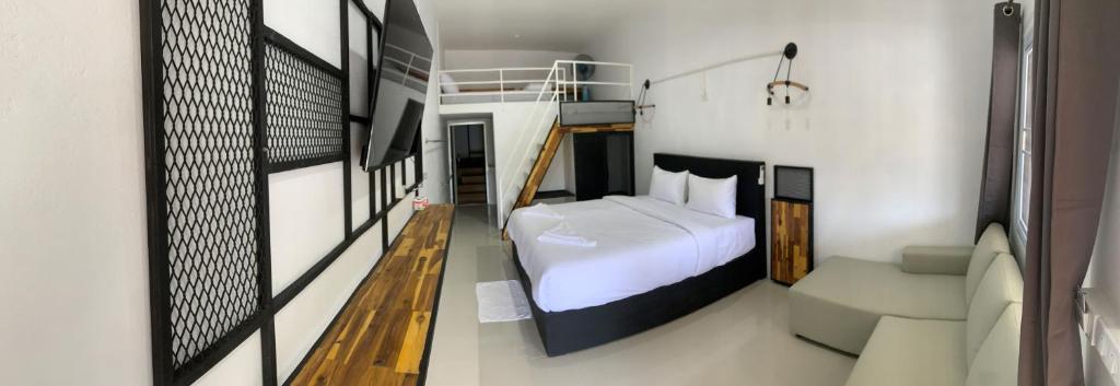 1 dormitorio con cama blanca y sofá en Amazing Inn Koh Tao, en Ko Tao