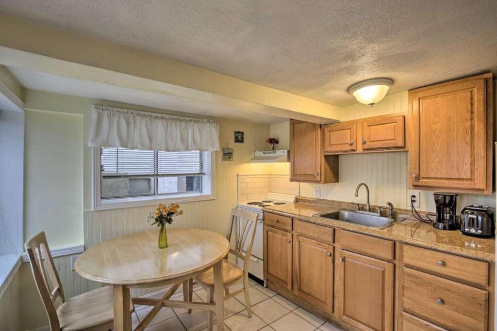 a kitchen with wooden cabinets and a table and a sink at Ground Floor Unit - The Americana in Hampton