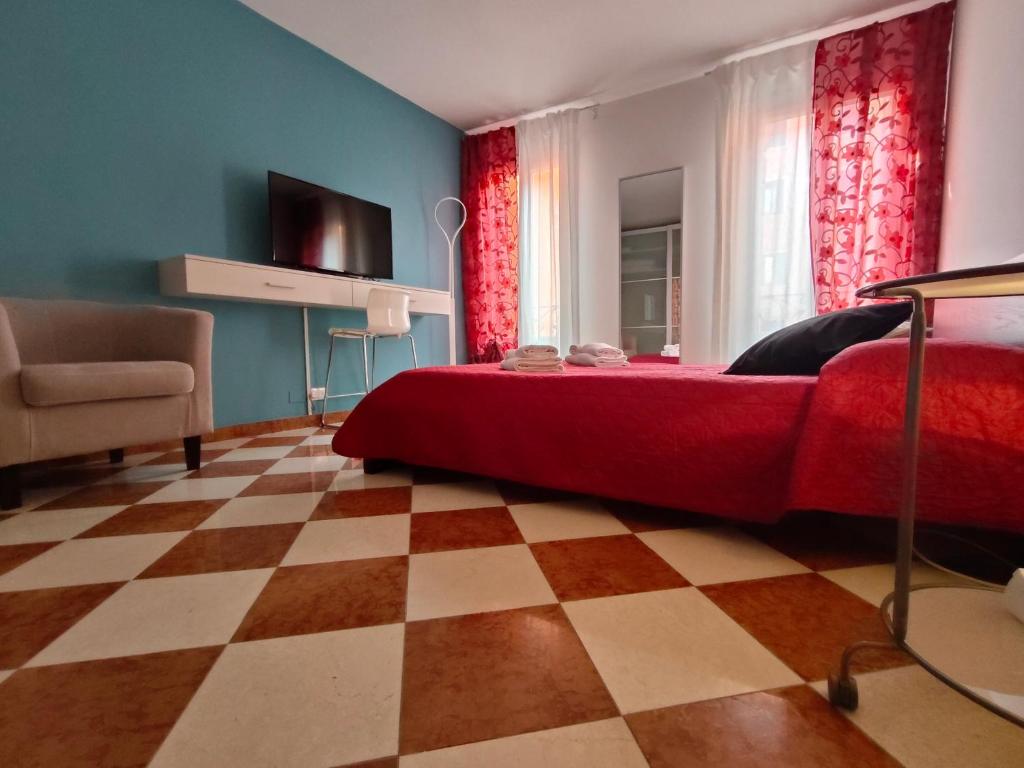 een slaapkamer met een rood bed en een geruite vloer bij San Marco Ca' Tiepolo in Venetië