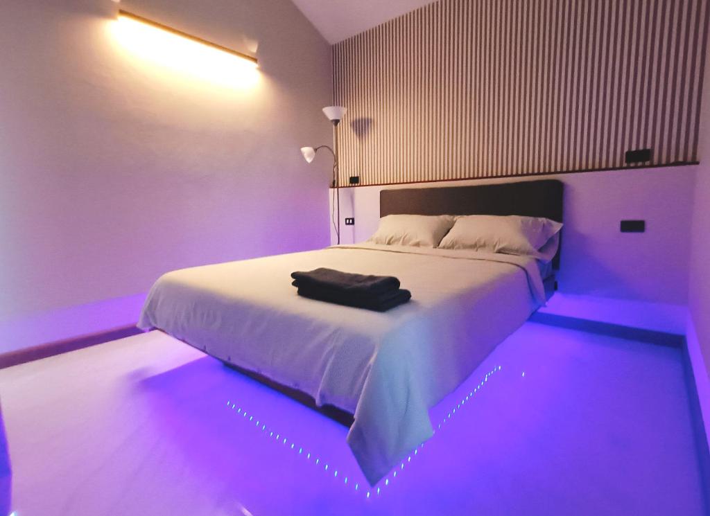 una camera da letto con letto bianco e illuminazione viola di Hormduk Resort a Udon Thani