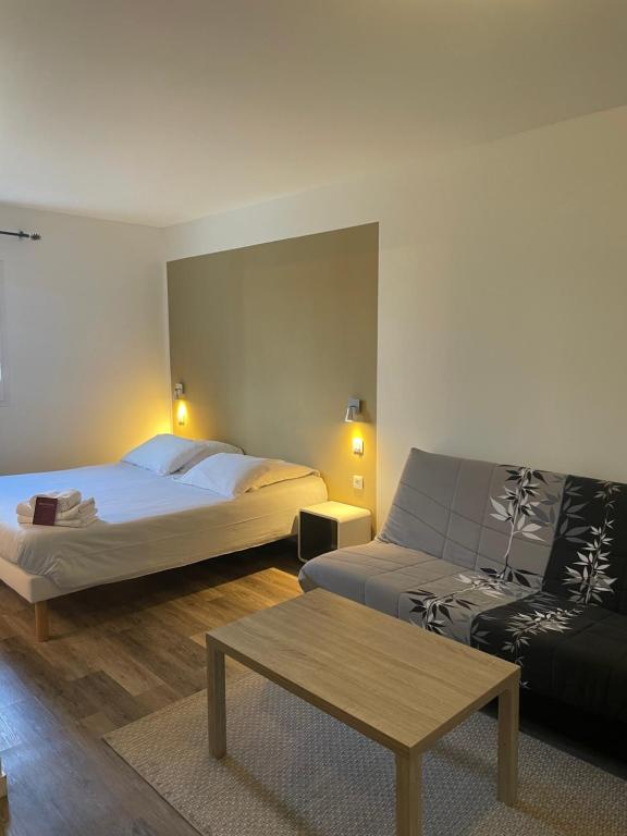 SauvagnonにあるHôtel Némo Aéroport de Pau - KB HOTEL GROUPのベッドとソファ付きのホテルルーム
