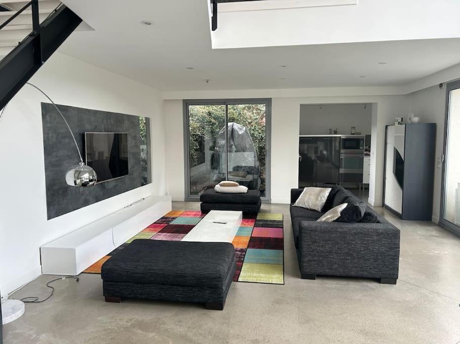 a living room with two couches and a rug at Maison avec piscine in Bièvres