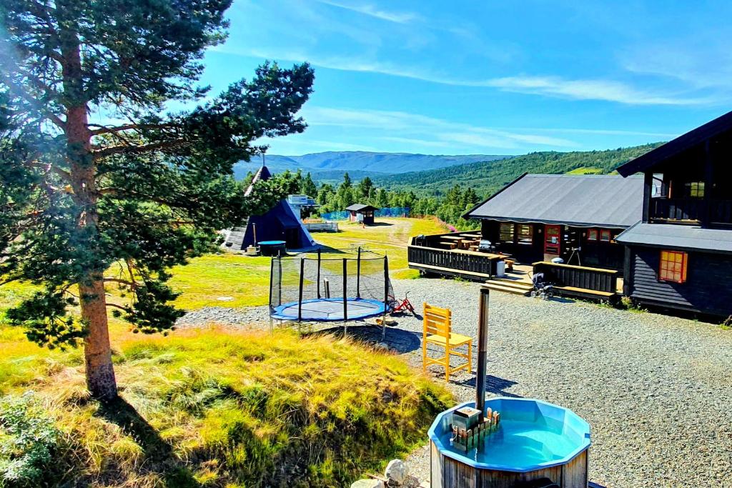 een speeltuin met een schommel en een huis bij Active Adventure Base - Apartment & Lavvo, Dagali Fjellpark in Dagali