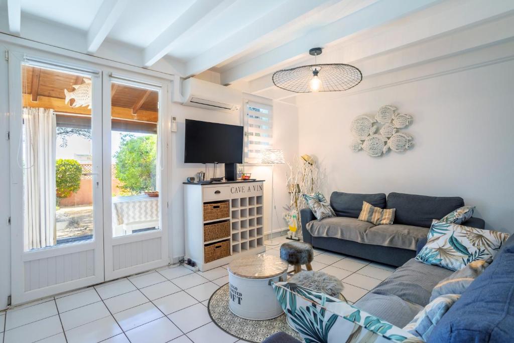 un salon avec un canapé et une télévision dans l'établissement Maison 4 chambres fb112, au Barcarès