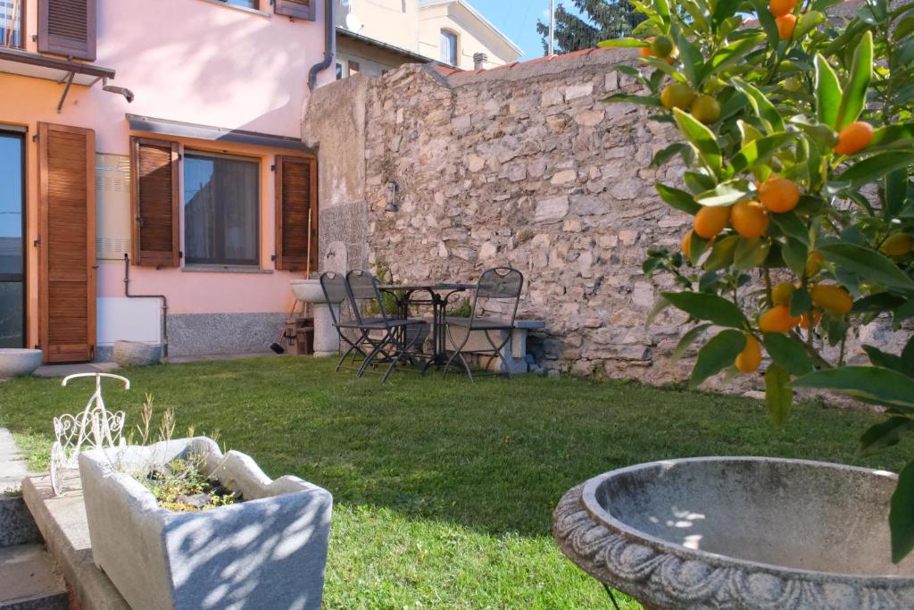 un giardino con un albero di arancio e un muro di pietra di Cà di Strii a Cernobbio