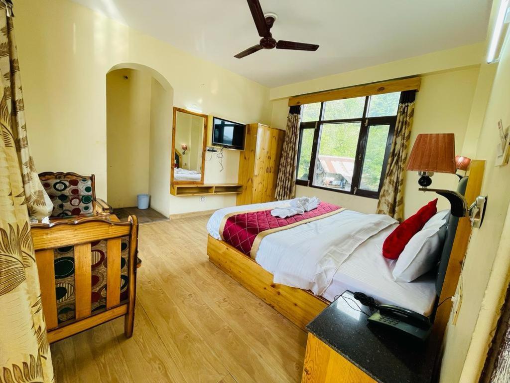 sypialnia z dużym łóżkiem i oknem w obiekcie ROYAL HILLS w mieście Manāli