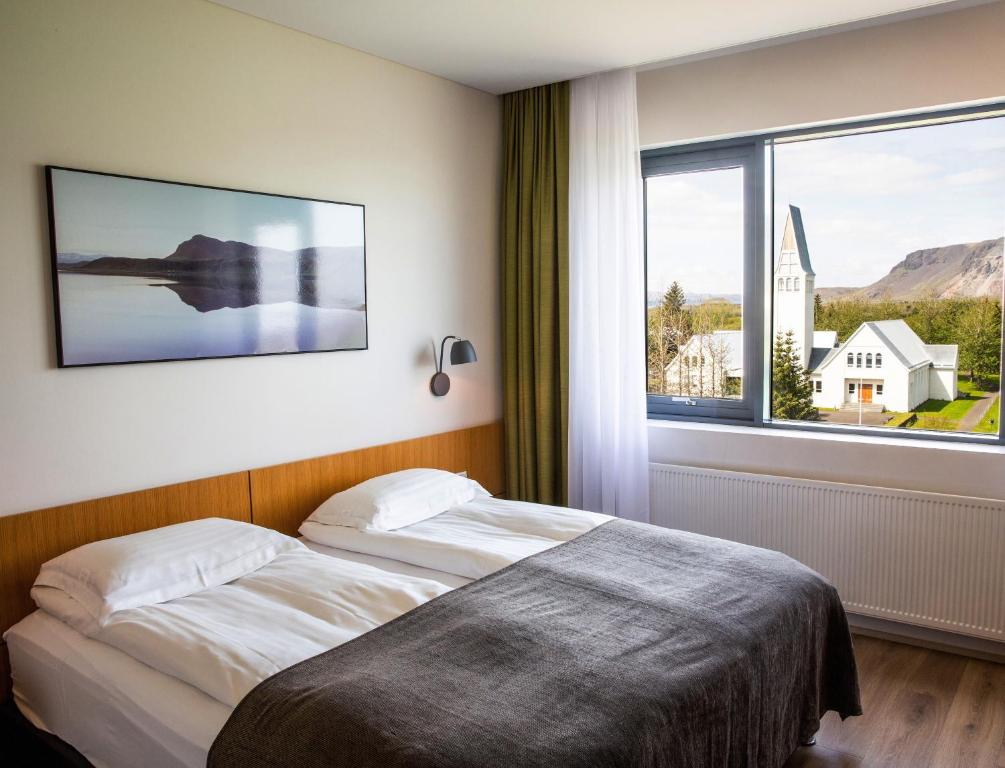 Hotel Selfoss في سيلفوس: غرفة نوم بسرير ونافذة كبيرة