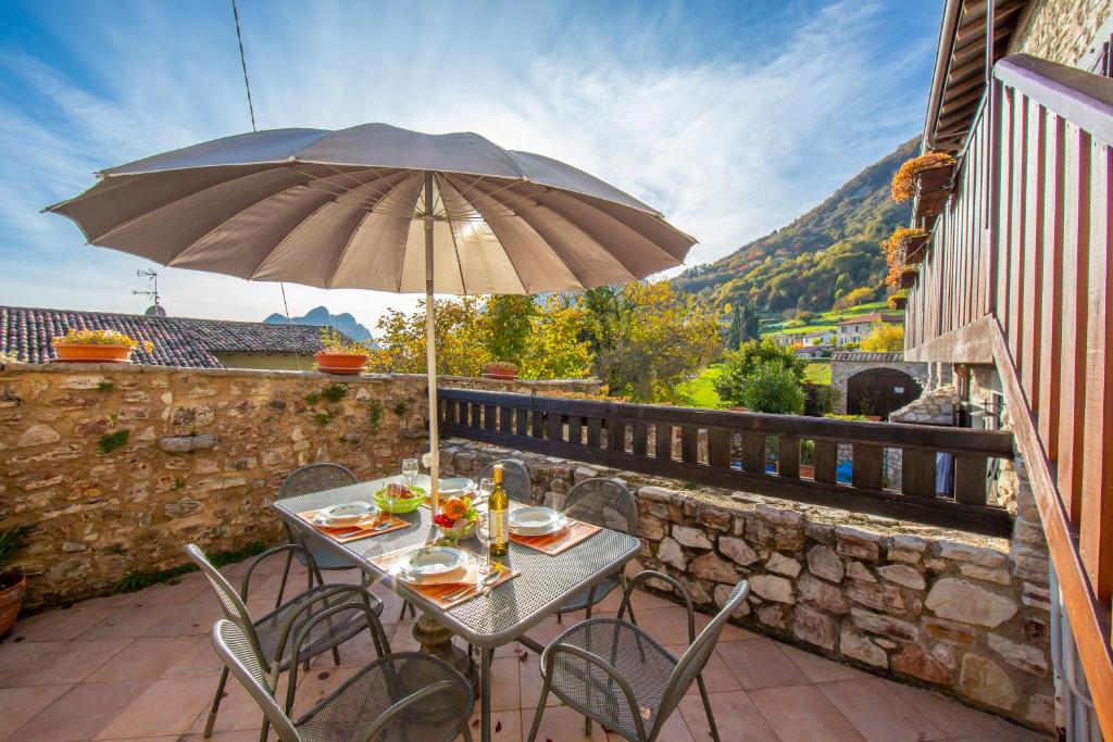 a table and chairs with an umbrella on a patio at Orchidea in Hilly area - Happy Rentals in Gargnano