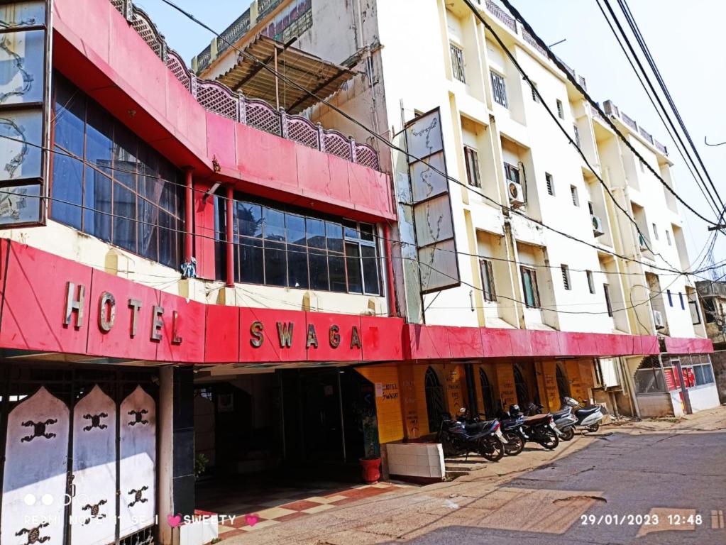 a hotel with a red sign on the front of a building at Hotel Swagat Bhubaneswar in Bhubaneshwar